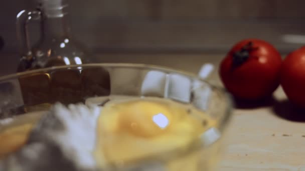 Закрыть процесс ручной работы теста из муки. Куриные яйца и груду белой муки в стеклянной миске. Процесс приготовления равиоли. 4К видео. Слоумоция — стоковое видео