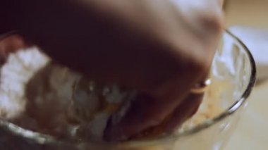 Kadın eli cam kasede yemek malzemelerini karıştırıyor. Ravioli için hamur yoğurur. Evde ravioli hazırlama süreci. 4K video