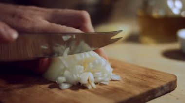 Kadın eli, soğanın yarısını tahta tahtada bıçakla küp küp doğruyor. Evde ravioli hazırlama süreci. 4 K video