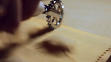 Mangırı et dolgusu ile kesmek için ravioli jant kesicisi kullanan kadın elinin yakın çekimi. Tipik bir İtalyan yemeği olan ravioli hazırlamak, eski İtalyan geleneğine göre ev yapımı. 4K video.