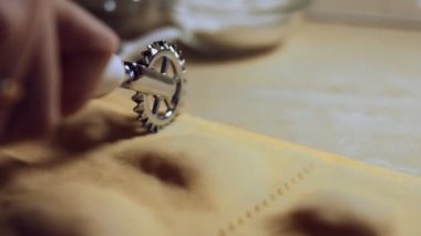 Mangırı et dolgusu ile kesmek için ravioli jant kesicisi kullanan kadın elinin yakın çekimi. Tipik bir İtalyan yemeği olan ravioli hazırlamak, eski İtalyan geleneğine göre ev yapımı. 4K video.