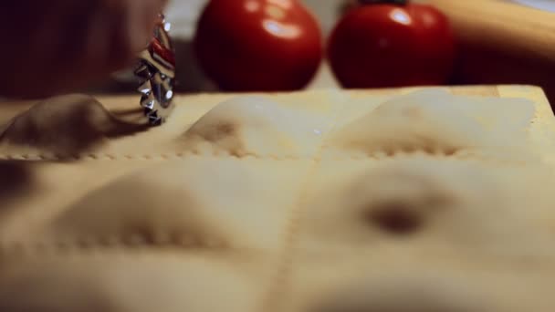 Närbild av kvinnor hand med ravioli hjul cutter för att skära degen med kött fyllning inuti. Lagar ravioli, en typisk italiensk maträtt, hemlagad enligt den gamla italienska traditionen. 4K-video. — Stockvideo