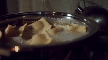 Tavada ravioli pişirme ve kaynar su. Tipik bir İtalyan yemeği olan ravioli hazırlamak, eski İtalyan geleneğine göre ev yapımı. 4K video