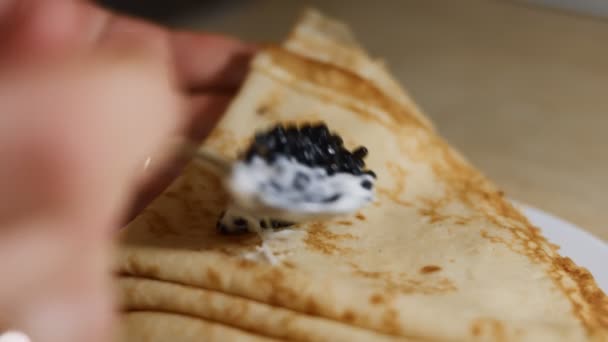 Épandage d'oeufs noirs de poisson en morceaux avec taramasalata sur les blinis. macro à gros plan isolée. Vidéo 4K — Video