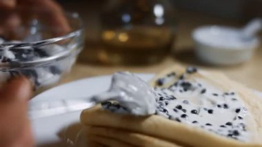 Krep üzerine taramasalata katılmış siyah balık yumurtası yaymak. İzole edilmiş yakın çekim makro. 4K video