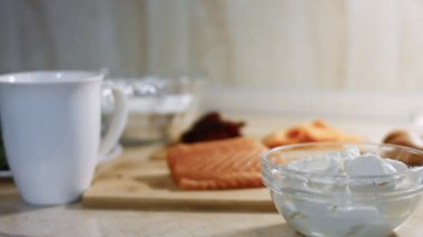 İnce, renkli krepler. Krem peynirli ve somon dolgulu kırmızı, sarı ve yeşil krep hazırlamak için malzemelerin yakın çekimi. 4K video.