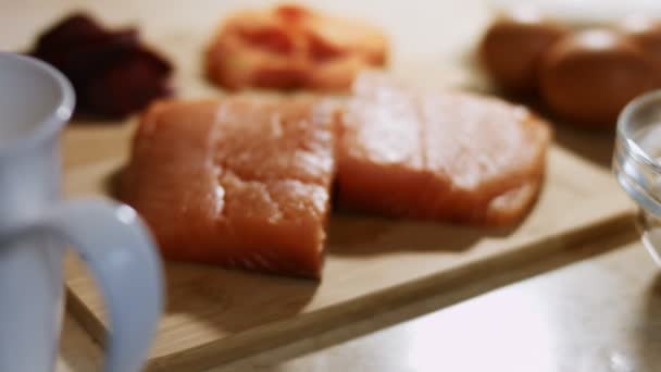 Close-up of fresh salmon fillet on a wooden board ready to be prepared. 4K video — Stockvideo