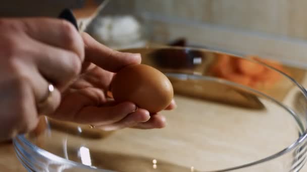 Frau knackt rohes Ei mit Messer über einer Schüssel. Prozess der Zubereitung von Pfannkuchen. 4K-Video — Stockvideo