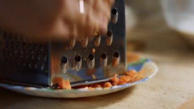 Ev mutfağındaki öğütücüye havuç süren kadın eli. 4K video