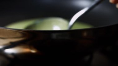 Krep pişirmek için tavaya yeşil krep hamuru serpiştiriyorum. Renkli krep hazırlama süreci. 4K video