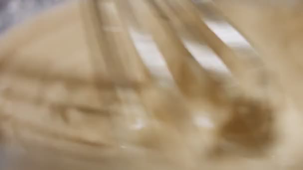 宏观视图混合新鲜的鸡蛋，面粉和牛奶与钢制的手搅拌器在一个玻璃碗。煎饼的制作过程。4K视频 — 图库视频影像
