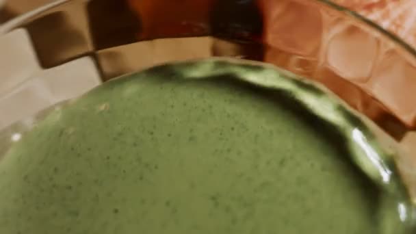 Frullare la pastella di pancake e le foglie di spinaci freschi in una ciotola di vetro. Processo di preparazione di frittelle colorate. Video 4K — Video Stock