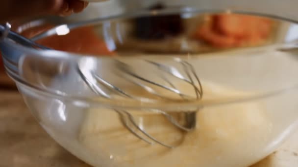 Amestecarea ouălor proaspete cu mixer de mână din oțel într-un castron de sticlă. Adaugă sare. Procesul de preparare a clătitelor. 4K video — Videoclip de stoc