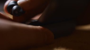 Modern kulaklıkların şarj edilme süreci. Erkek olan kulaklığı çantaya koyup şarj etmek için kapatıyor. 4K video