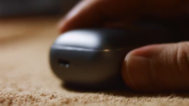 Şarj çantasındaki kablosuz kulaklıkların kabloya bağlı olduğu yakın plan. Modern kulaklıkların şarj edilme süreci. 4K video