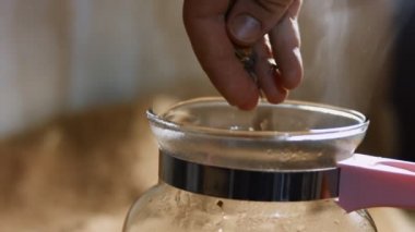 Sıcak suyla şeffaf bir fincana çay yaprakları ve çiçekler dökmek. Sri Lanka 'dan gelen aromatik ve rahatlatıcı çay hazırlanıyor. Sağlıklı yaşam tarzı kavramı. 4K video