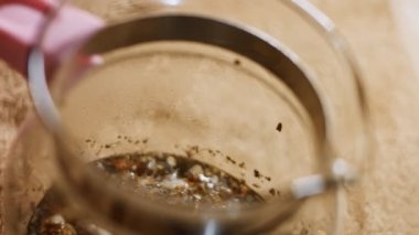 Şeffaf bir çaydanlıkta Sri Lanka 'dan gelen aromatik ve rahatlatıcı çay karışımına yakından bakın. Sağlıklı yaşam tarzı kavramı. 4K video.