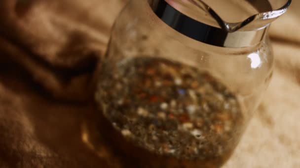 Närbild av aromatisk och avkopplande infusion av te från Sri Lanka i en transparent tekanna. Friska livsstil koncept. 4K-video. Långsamma rörelser — Stockvideo