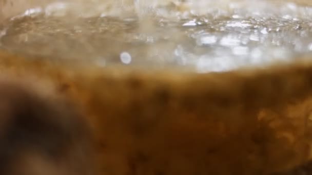 Closeup of pouring hot water in a transparent teapot with dried marigold calendula flowers. Preparing infusion of marigold calendula flowers as herbal therapy. Healthy lifestyle concept. 4K video — Stockvideo