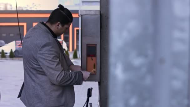 L'homme en lave-auto libre-service insère de l'argent pour une utilisation sur un accepteur de factures. Vidéo 4K — Video