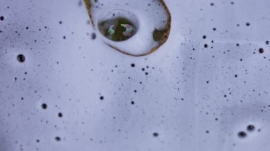 Oto yıkama, oto yıkama, yukarıdan görüş. Toz ve yapraklarla karıştırılmış köpük yerde süzülüyor. 4K video