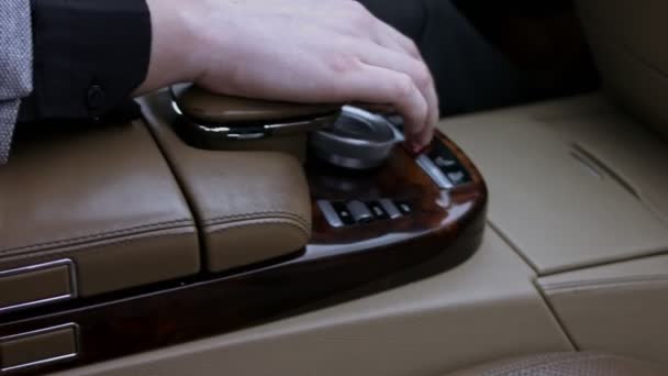 Το δάχτυλο του οδηγού πατάει το κουμπί προειδοποίησης κινδύνου στο γυαλιστερό ταμπλό του αυτοκινήτου. Το κουμπί αναβοσβήνει κόκκινο. Πολυτελές εσωτερικό αυτοκινήτου. Κοντινό πλάνο. Βίντεο 4K — Αρχείο Βίντεο