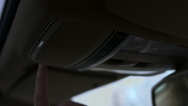 Supporto per occhiali da sole sul tetto anteriore in un interno di auto. Mano maschile preme il pulsante per aprire il porta occhiali da sole. Video 4K — Video Stock