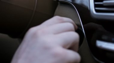 Arabasını anahtarla çalıştıran bir erkeğin yakın çekimi. Lüks araba iç mekanı. 4K video