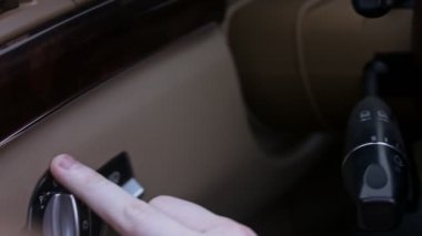 Arabada cam sileceği ve çamaşır makinesi kullanan bir erkek el. Lüks araba iç mekanı. 4K video