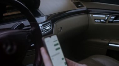Arabada otururken internet üzerinden mesaj yazan tanınmayan bir adamın son derece yakın çekim elleri. Otomatik telefon kullanan iş adamının yakın görüntüsü. 4K video