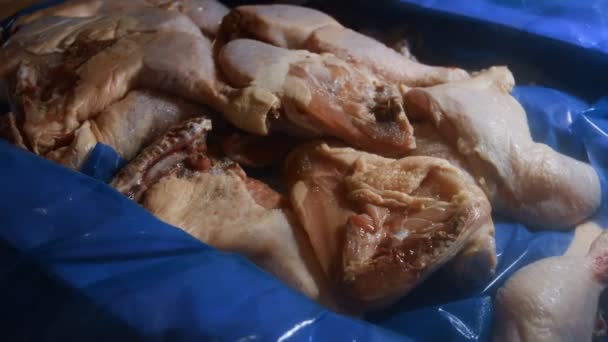 Vista de perto de uma caixa cheia de pernas de frango congeladas. Carne de frango crua congelada coberta de gelo. 4k vídeo — Vídeo de Stock