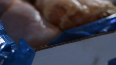 Donmuş tavuk bacağıyla dolu bir kutunun makro görüntüsü. Buzla kaplı donmuş çiğ tavuk eti. 4k video