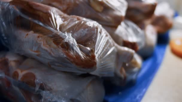 Close-up van verpakte kippenpoten in individuele plastic zakken. Invriezen van vlees voor verder gebruik thuis. 4K-video — Stockvideo
