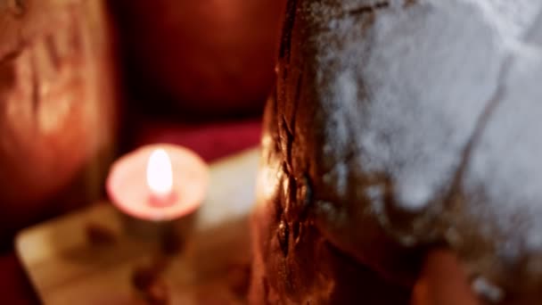 Zucchero a velo in cima al delizioso Panettone di Milano in una splendida atmosfera di candele. Pasticcini tradizionali italiani per Natale con frutta secca. Fetta di panettone mostrata da vicino. Video 4K — Video Stock