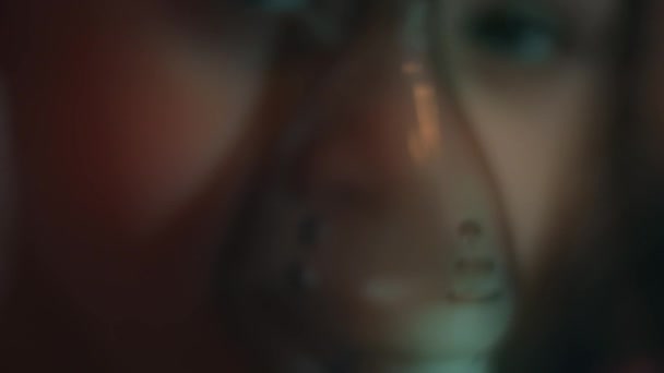 Portret pięknej dziewczynki wykonującej inhalację przy użyciu inhalatora sprężarkowego siedząc na sofie. 5 lat. trzymając maskę nebulizatora i wdychając opary soli fizjologicznej. Wideo 4K — Wideo stockowe