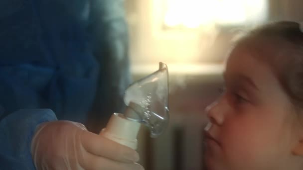 Fetița frumoasă face inhalare folosind un inhalator de compresor la spital. 5 y.o. fata care inhalează vapori salini cu mască de nebulizator pe față și tuse. Doctorul ajută fetița să facă inhalare — Videoclip de stoc
