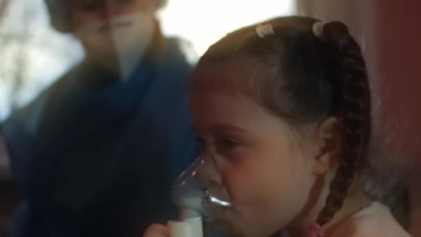 Hermosa niña hace inhalación usando un inhalador de compresor en el hospital. 5 años de edad chica inhalando vapores salinos con máscara de nebulizador en su cara. El médico ayuda a la niña a inhalar en el hospital — Vídeos de Stock