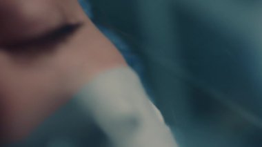 Laboratuvarda kameraya bakan kendine güvenen bir doktorun yorgun gözleri. Coronavirus salgını sırasında hastanede çalışan tıbbi koruyucu maskeli ve vizörlü bir kadın. 4K video. Yavaş çekim