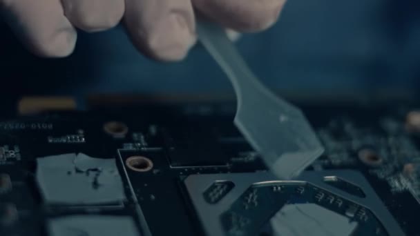 GPU grafikus kártya. Makro nézet a technikusok kéz terjesztése új termikus paszta egy chip. 4K videó. — Stock videók