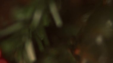 Dekorasyon ve ışıklarla sahte Noel Ağacı 'nın yakın çekimi. Noel Ağacı 'nın süsleri ve ışıklarıyla dallarda dolaşmak sihirli bir atmosferdir. Seçici odaklanma. 4K video