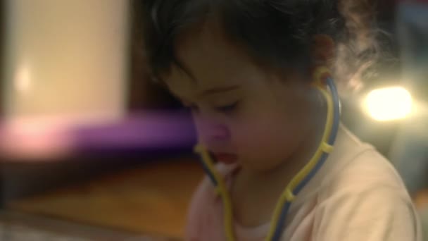 Visão de close-up da menina bonito jogando médico com ferramentas médicas de brinquedo. Menina feliz em casa. Vídeo 4K — Vídeo de Stock