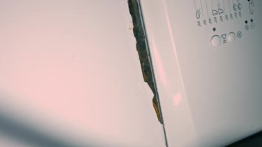 İç mekanda çalışan paslı bir çamaşır makinesinin yakın çekim görüntüsü. Çamaşır makinesinin tadilata ihtiyacı var. 4K video. Döndürme