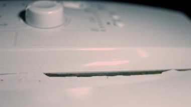 İç mekanda çalışan paslı bir çamaşır makinesinin yakın çekim görüntüsü. Çamaşır makinesinin tadilata ihtiyacı var. 4K video