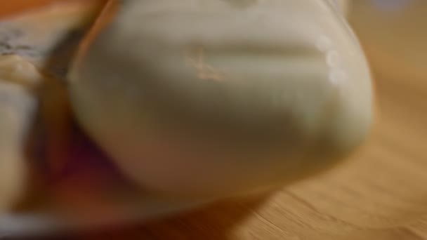 Différents types de fromages salés et frais et jambon de porc prêts à être coupés en apéritif, vidéo 4K. Tournage artistique — Video