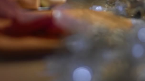 Prosciutto di maiale affettato disposto su un vassoio di legno come antipasto. Video 4K. — Video Stock