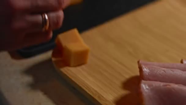 Kostki sera Cheddar są układane na drewnianej tacy jako smaczne i atrakcyjnie wyglądające przystawki. Nagranie 4K. Ramy czasowe — Wideo stockowe