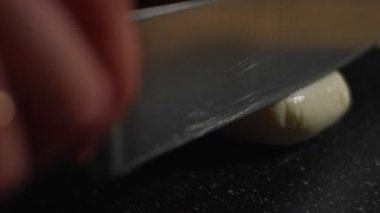 Mozzarella 'nın kesim tahtasıyla dilimlenmesi. 4K video