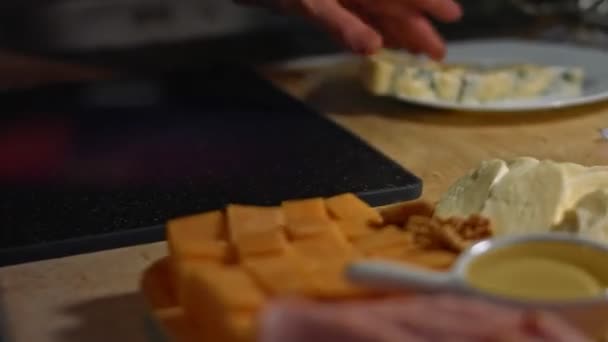 Το δανέζικο μπλε τυρί κόβεται σε κύβους σε ένα ξύλο κοπής. Βίντεο 4K. Καλλιτεχνική σκοποβολή — Αρχείο Βίντεο