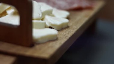 Taze İtalyan dilimlenmiş salam sosisi ve kalp şeklinde mozzarella peyniri ahşap bir tepsi üzerinde, sevgililer günü için kalp şeklinde pizza hazırlıyor. 4K video. Sanatsal çekim