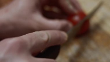 Tahtada mutfak bıçağıyla kırmızı kiraz domateslerini dilimlemek, sevgililer günü için kalp şeklinde pizza hazırlamak. 4K video